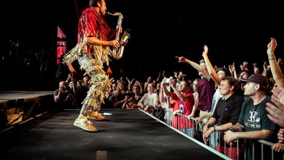 Pepe plays his sax on stage in front of a big crowd